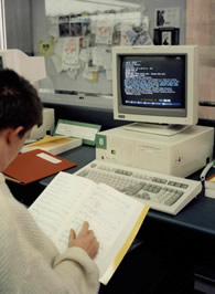 A client using ERIC on CDROM while checking the Library’s journals holdings on the printed journal listing, c 1990