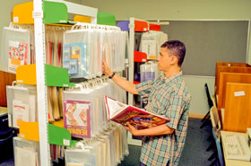 Audiovisual material in special packaging and shelving in the Library, c 1992