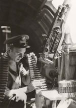 A United States machine gunner of a Flying Fortress loading a magazine before taking off from a base somewhere in Australia, 1942.