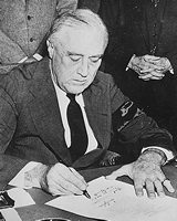 Photograph of President Franklin D. Roosevelt Signing the Declaration of War Against Japan, 12/08/1941, White House photographs taken by Abbie Rowe, 1941-1967, National Archives, ARC ID 520053.