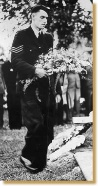 John F Curtin laying the family wreath on his father's grave.