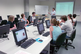 A faculty librarian presenting a training session on searching electronic journal databases in the level three training room in 2004.